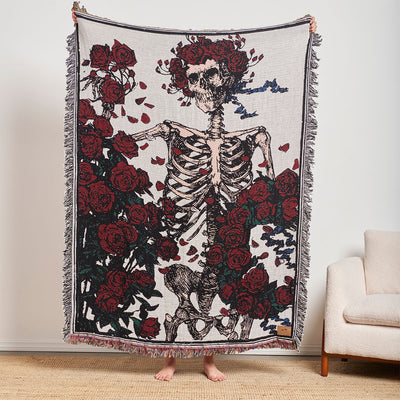 Tapestry with skeleton and red roses pattern, displayed on a chair.