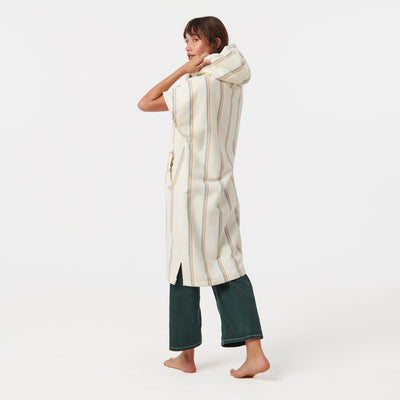 Hooded striped fouta robe with green pants.