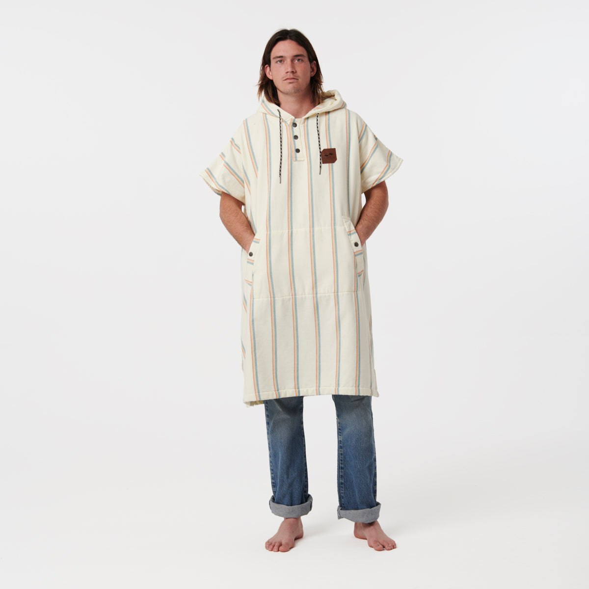 Hooded striped poncho in fouta fabric with rolled-up jeans.