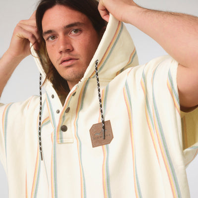 Hooded poncho in striped fouta fabric with drawstrings and leather chest patch.