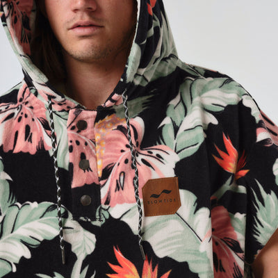 Hooded absorbent poncho with floral pattern and chest patch.