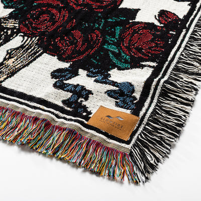 Oversized woven blanket with multicolored fringe and unique pattern.