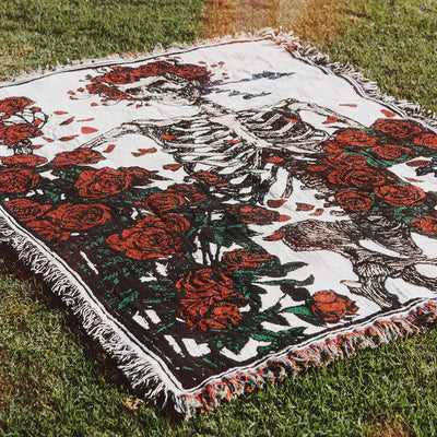 Oversized blanket with skeleton, red roses, and greenery design.