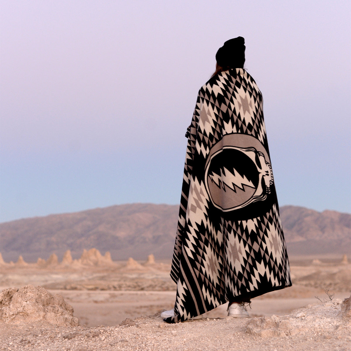 Sand free blanket with geometric pattern on sandy ground.