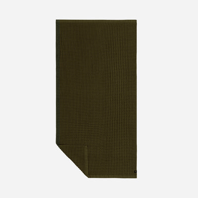 Quick dry olive green towel with waffle texture, neatly folded on plain background.